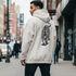 Man wearing a hoodie with a tiger design on a city street