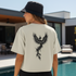 Person wearing a white t-shirt with a black phoenix design outdoors by a pool.